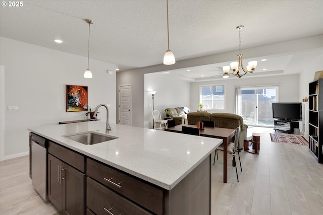 kitchen featuring dishwasher, decorative light fixtures, a raised ceiling, and sink