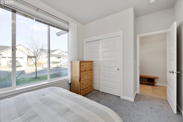 bedroom with light colored carpet and a closet