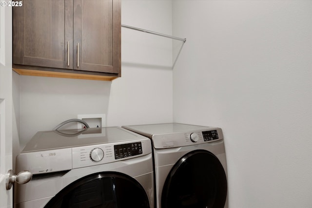 washroom with cabinets and washer and clothes dryer