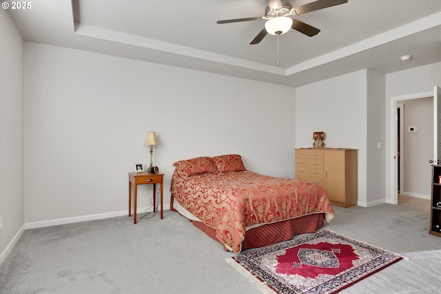 bedroom featuring a tray ceiling, ceiling fan, and light colored carpet