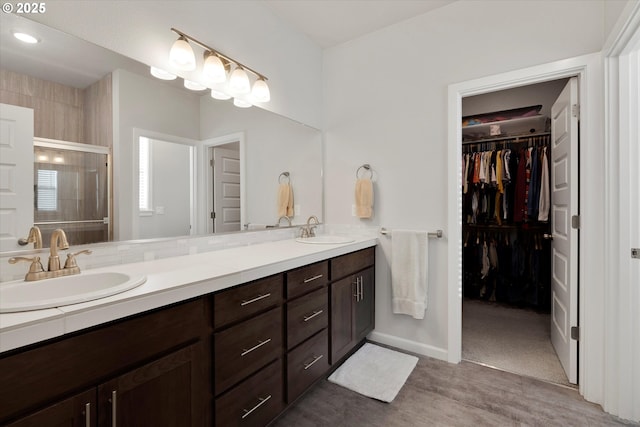 bathroom with vanity and a shower with door