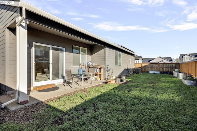 back of house with a lawn, central AC unit, and a patio