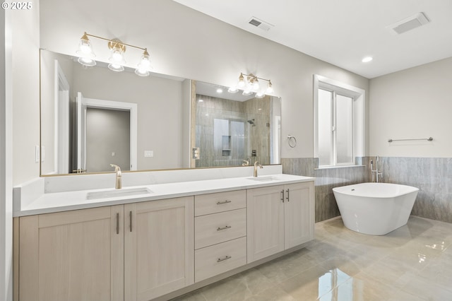 bathroom with vanity, separate shower and tub, and tile walls