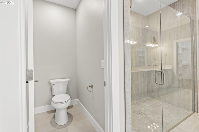 bathroom featuring tile patterned floors, a shower with door, and toilet