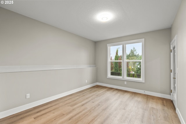 unfurnished room featuring a textured ceiling and light hardwood / wood-style floors