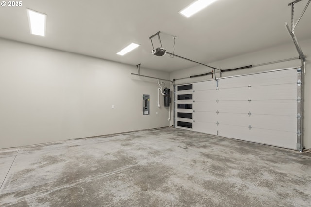 garage with a garage door opener and electric panel