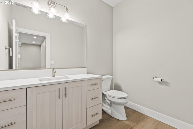 bathroom featuring hardwood / wood-style flooring, vanity, and toilet