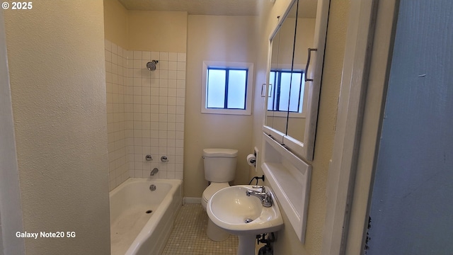 bathroom featuring baseboards,  shower combination, a sink, tile patterned flooring, and toilet