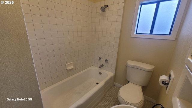 bathroom with tile patterned floors, toilet, washtub / shower combination, and baseboards