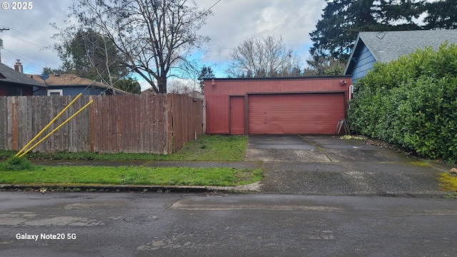 detached garage featuring fence