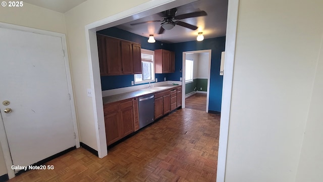 kitchen featuring a sink, light countertops, baseboards, dishwasher, and ceiling fan