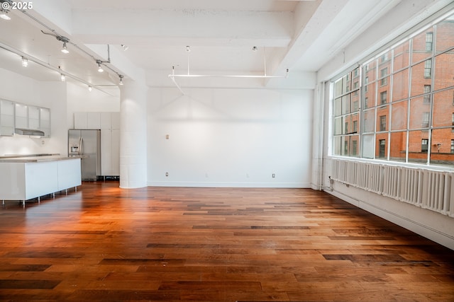 interior space with track lighting, baseboards, and wood finished floors