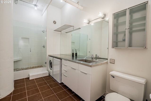 bathroom featuring tile patterned floors, toilet, washer / clothes dryer, and a shower stall