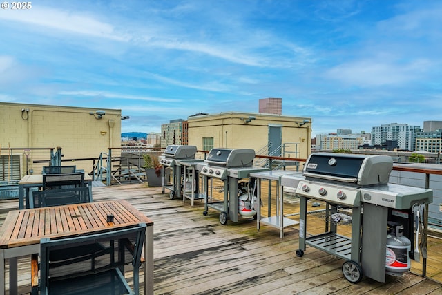 wooden deck featuring a city view and a grill