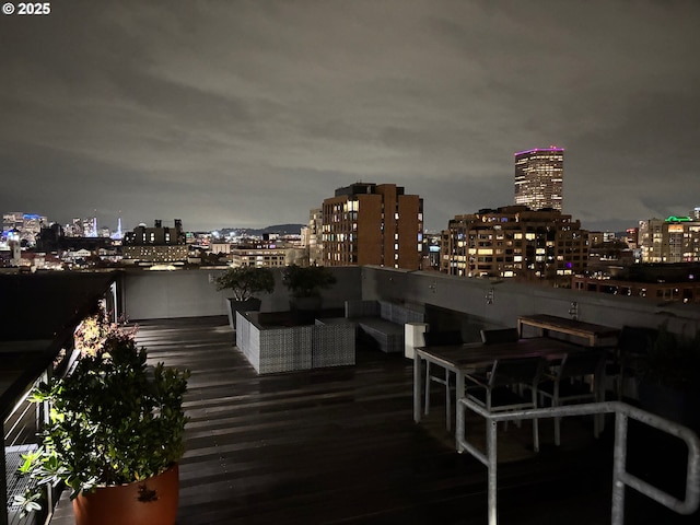 deck at twilight featuring outdoor lounge area and a view of city lights