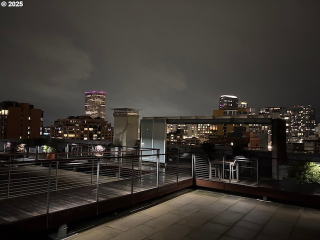 balcony at twilight featuring a view of city lights