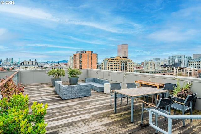 wooden terrace featuring an outdoor hangout area and a city view