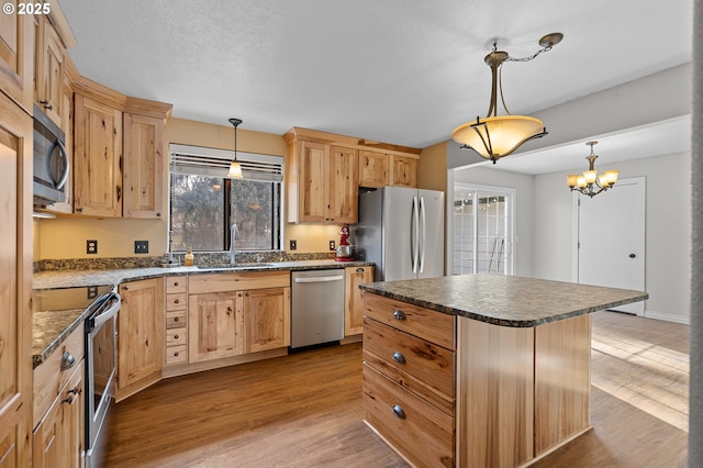 1524 SW 44th St, Pendleton, OR 97801 - kitchen with appliances with stainless steel finishes, dark countertops, wood finished floors, a sink, and light brown cabinets