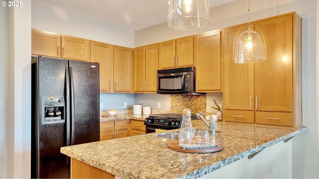 kitchen with hanging light fixtures, black appliances, kitchen peninsula, and light brown cabinets