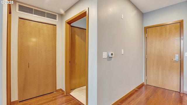 hallway with light hardwood / wood-style floors