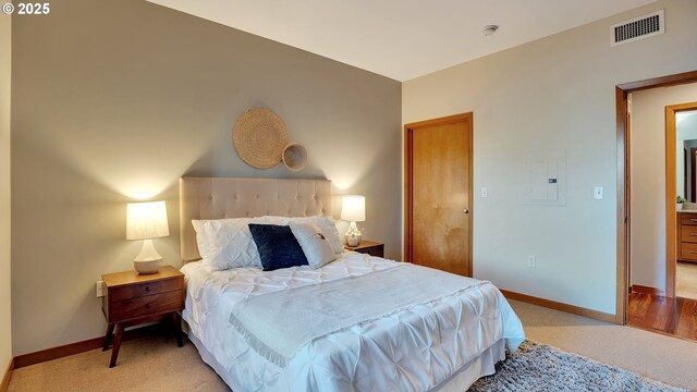 bedroom featuring electric panel and light carpet