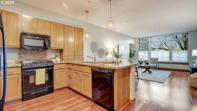 kitchen featuring pendant lighting, black appliances, sink, kitchen peninsula, and light brown cabinets