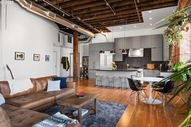 living room with a towering ceiling and light hardwood / wood-style floors