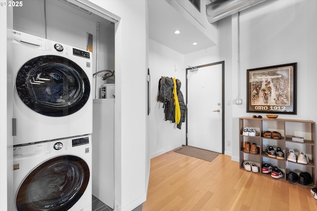 clothes washing area with stacked washer / drying machine and hardwood / wood-style flooring