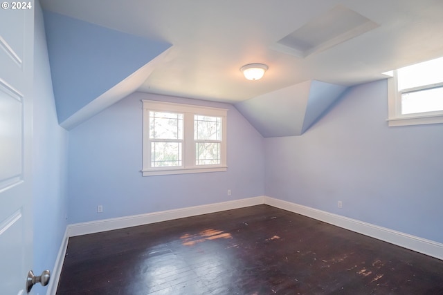 bonus room with baseboards, lofted ceiling, and hardwood / wood-style flooring