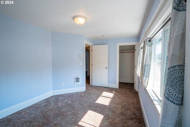 unfurnished bedroom featuring a closet, visible vents, baseboards, and carpet floors