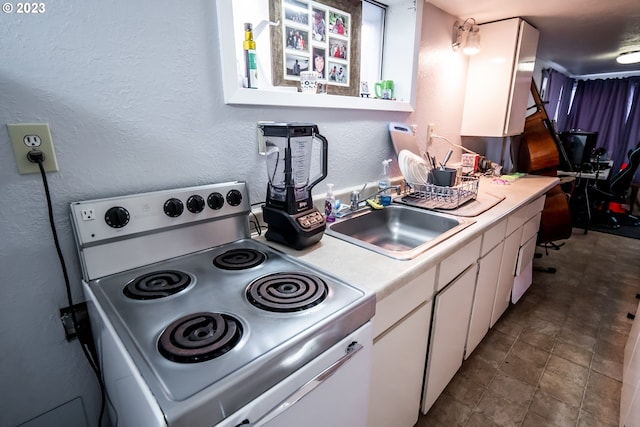 kitchen with white electric stove, white cabinets, light countertops, and a sink