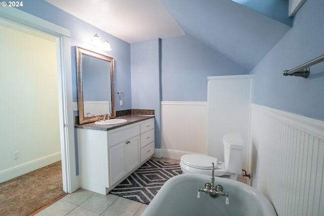 bathroom featuring a wainscoted wall, a freestanding bath, vanity, and toilet