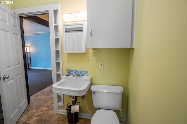 bathroom with a sink, baseboards, and toilet