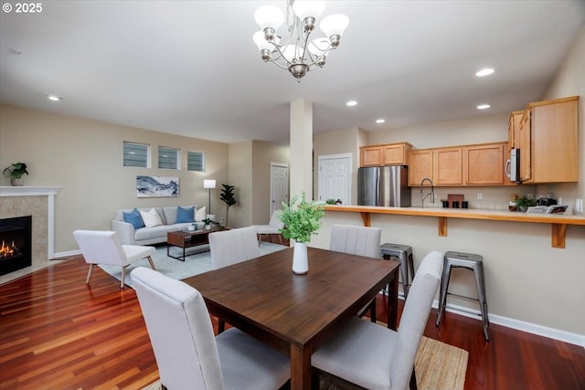 249 NW Mandi St, Hillsboro, OR 97124 - dining area with wood finished floors, recessed lighting, a chandelier, baseboards, and a tile fireplace