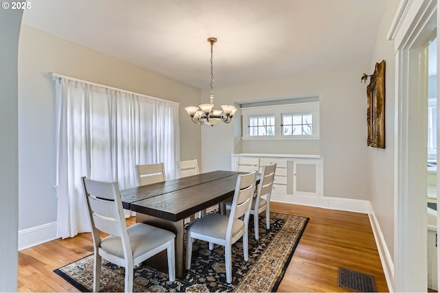 dining space featuring baseboards, visible vents, and light wood finished floors