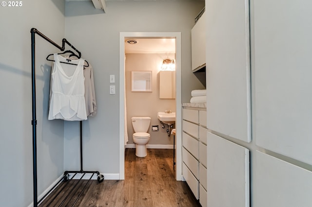 bathroom with hardwood / wood-style flooring and toilet