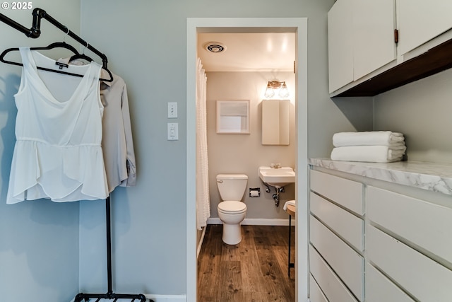 bathroom featuring hardwood / wood-style floors and toilet