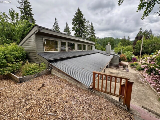 892 S 55th Pl, Springfield, OR 97478 - view of side of property with a vegetable garden, a wooden deck, and a chimney