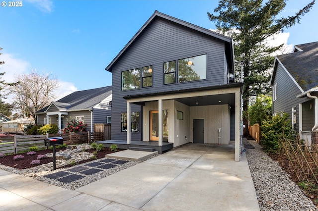 contemporary home featuring a porch, fence, and driveway