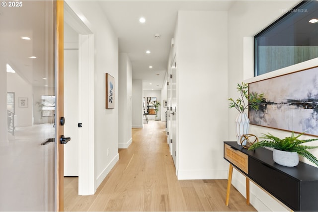 corridor featuring light wood finished floors, recessed lighting, and baseboards