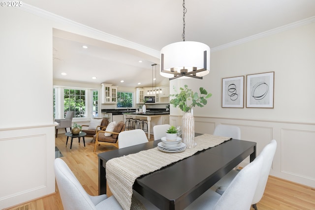 17243 Fernwood Dr, Lake Oswego, OR 97034 - dining room with crown molding, a wainscoted wall, light wood-style flooring, a decorative wall, and a chandelier