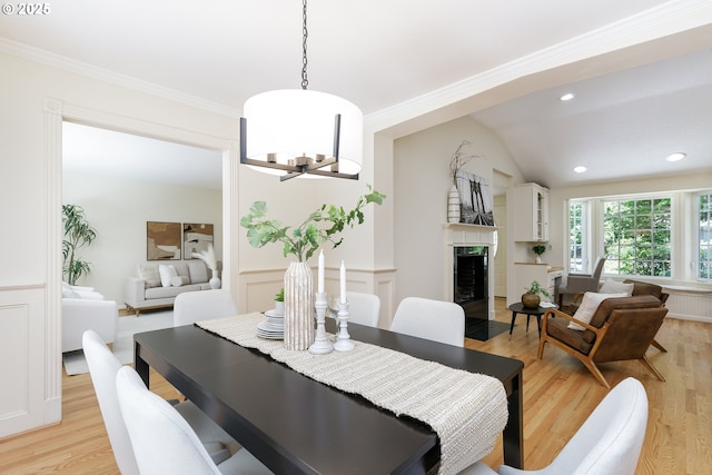 17243 Fernwood Dr, Lake Oswego, OR 97034 - dining room featuring light wood-style floors, a chandelier, a fireplace with flush hearth, wainscoting, and ornamental molding