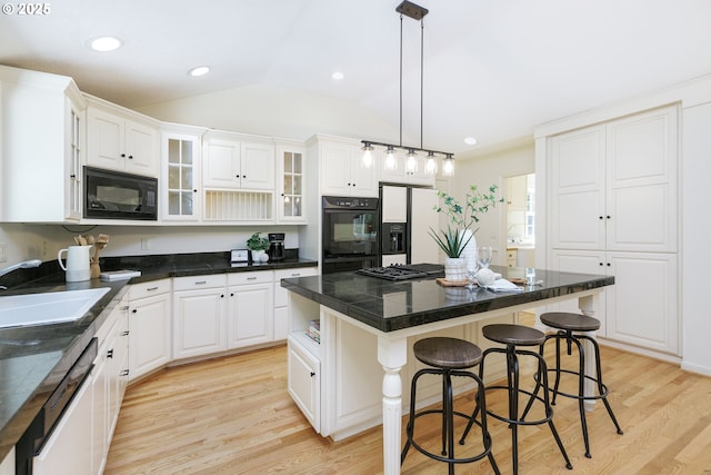17243 Fernwood Dr, Lake Oswego, OR 97034 - kitchen featuring black appliances, a sink, lofted ceiling, a kitchen bar, and a center island