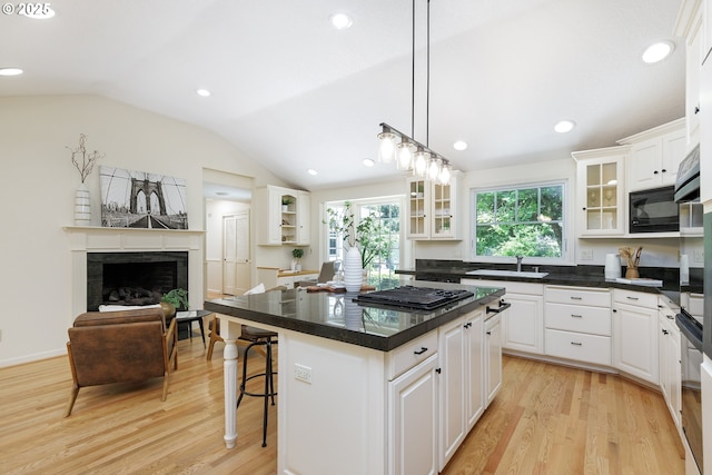 17243 Fernwood Dr, Lake Oswego, OR 97034 - kitchen featuring black appliances, a fireplace, a sink, vaulted ceiling, and light wood-type flooring
