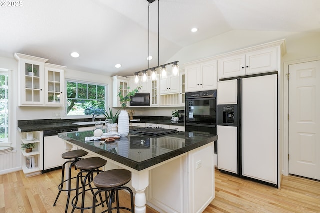 17243 Fernwood Dr, Lake Oswego, OR 97034 - kitchen with black appliances, lofted ceiling, light wood finished floors, white cabinets, and a breakfast bar