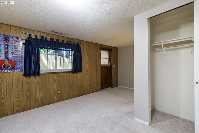 17243 Fernwood Dr, Lake Oswego, OR 97034 - unfurnished bedroom featuring carpet flooring, wooden walls, a closet, and a textured ceiling