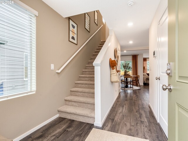 foyer featuring dark wood finished floors, stairs, recessed lighting, and baseboards