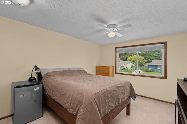 1415 SE 52nd Ave, Hillsboro, OR 97123 - bedroom featuring light carpet, baseboards, freestanding refrigerator, a textured ceiling, and ceiling fan