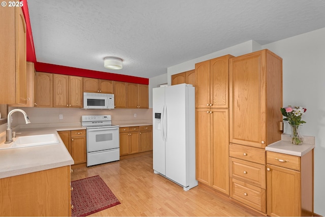 1415 SE 52nd Ave, Hillsboro, OR 97123 - kitchen with white appliances, a sink, light wood-type flooring, a textured ceiling, and light countertops