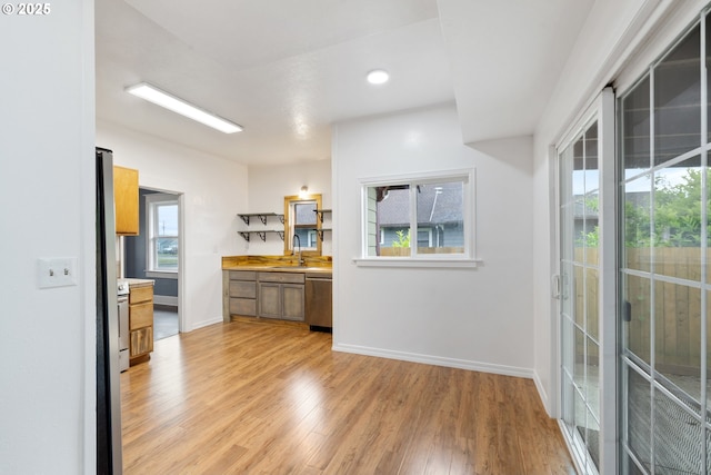 1006 Stillwell Ave, Tillamook, OR 97141 - kitchen with a sink, stainless steel dishwasher, light wood-type flooring, baseboards, and light countertops